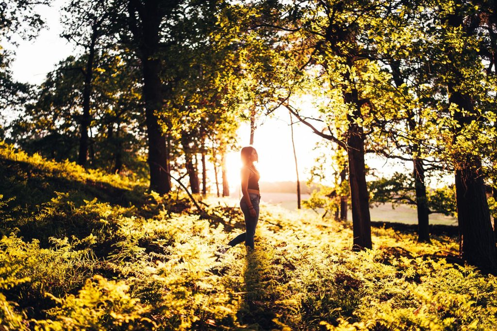 photo of woman standing in forest